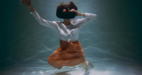 Woman Wearing VR Headset Floating Underwater