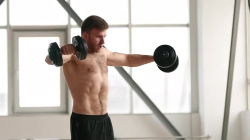 Young Dedicated Male Athlete Performing Heavy Weights Workout in Gym