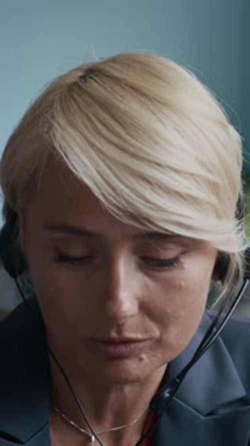 Blond Operator Speaking in Headset Microphone while Consulting Online Client