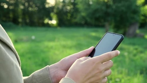Hands Use Mobile Phone Outdoors in Nature