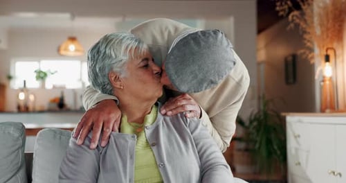 Old couple, kiss and love in home for support, connection and hug for comfort in lounge