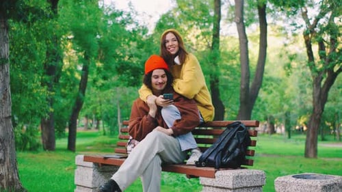 This Colorful Image Shows a Joyful Couple Enjoying a Sunny Day in a Park Happily Using Their