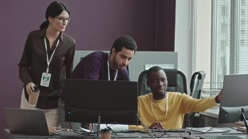 Colleagues Collaborate at Computer in Modern Office