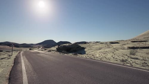 Winding Road Through the Rugged Terrain of Mongolia Under a Bright Sun