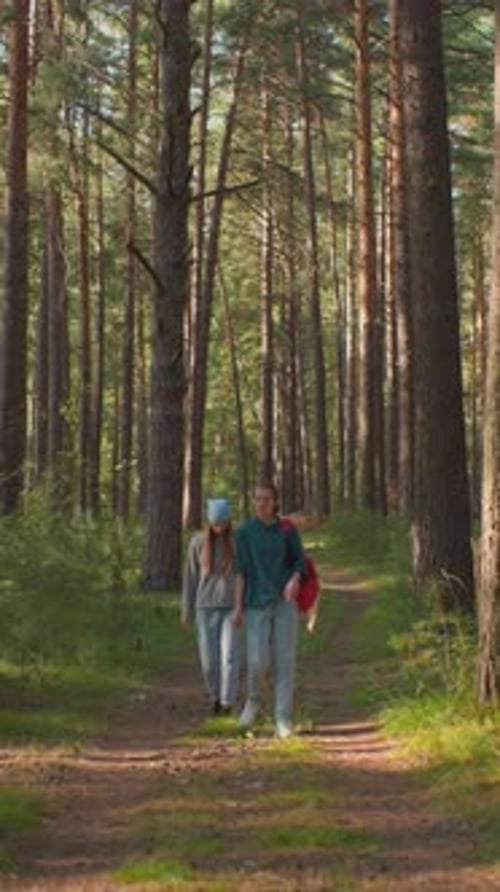 Friends Walking Through Serene Forest Path with Red Backpack and Draped Handkerchief