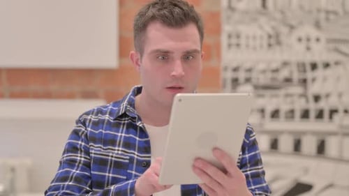 Portrait of Young Casual Man Upset by Loss on Tablet