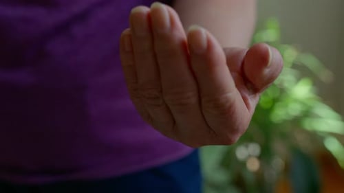 Close Up View of Elderly Hands Holding and Taking Medicine Pills in a Home Environment