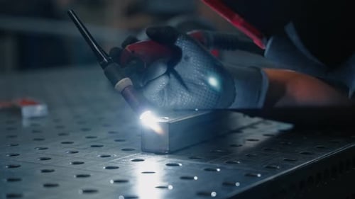 Metal Worker Welding Silver Block with Torch