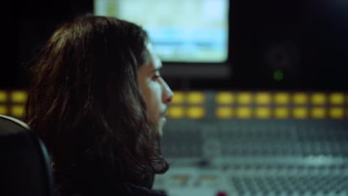 Sound engineer turns on chair in music studio portrait of male musician