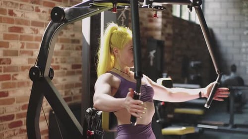 Gorgeous Female Professional Bodybuilder Doing Workout Exercises in Gym