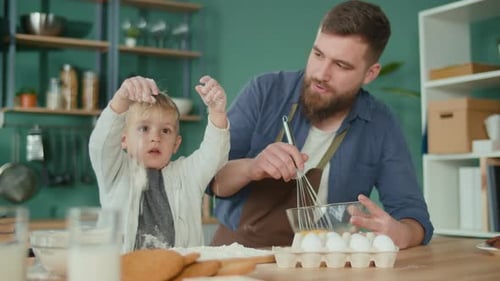 Bearded Man Baking with His Son in Kitchen