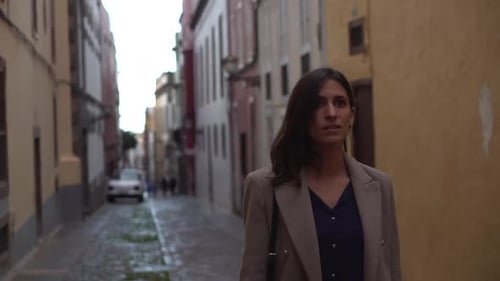 Woman walking through narrow street during winter with rain in Gran Canaria.