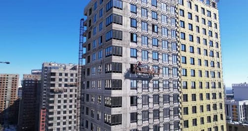 A Builder on a Suspended Cradle Construction of Highrise Buildings Drone View