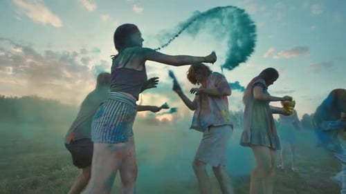 School Friends Sprinkled with Colorful Powders at Sunset