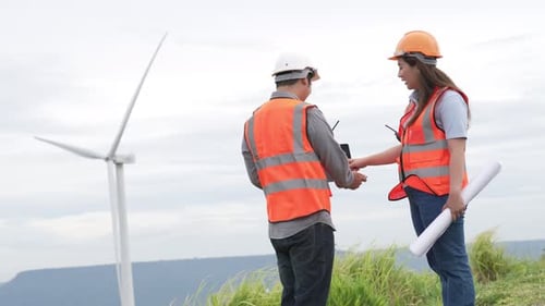 Progressive concept of engineers working in the wind farm atop of the mountain.