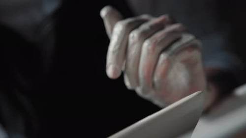 Artist Hands Shaping Clay in Dark Studio