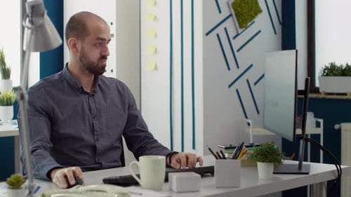 Man Works at Computer in Modern Workplace Office