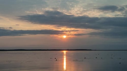 View of sunset on lake with colorful clouds.