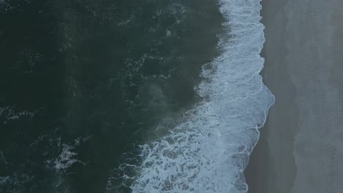 Top Down Aerial View Of Beach With Waves Crashing Into The Sand - static, slow motion