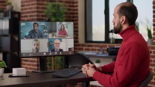 Office Worker Attending Videocall Meeting with Business People