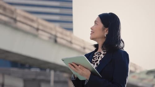 Professional Woman Using Tablet Outdoors in City