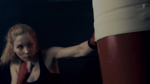 Energetic Woman Boxing with Punching Bag