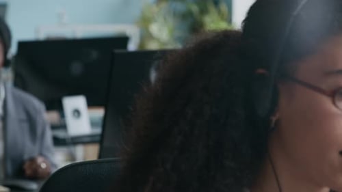 Intercultural Female Operators with Headsets Speaking to Online Customers