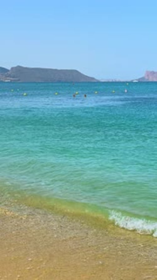 Playa del Albir in L'Alfàs del Pi, Costa Blanca, summer view of a sunny Spanish beach with swimmers