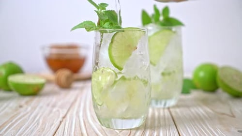 Lime Drink With Ice Being Poured Into Glass