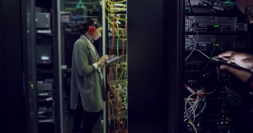 IT Professionals Working in a Dark Server Room