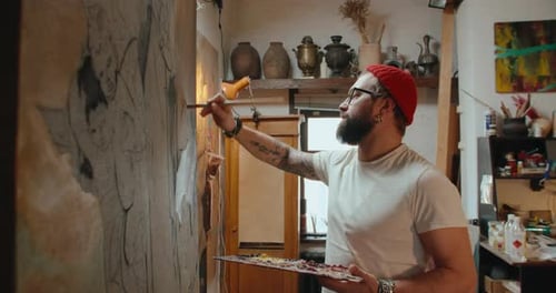 Male Artist Paints a Canvas in His Art Studio