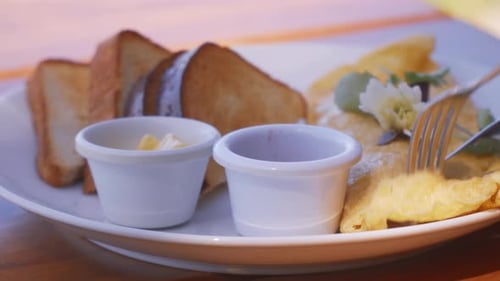 Cutting and eating an omelette with bread and sauces in the morning for breakfast. Camera tracking m