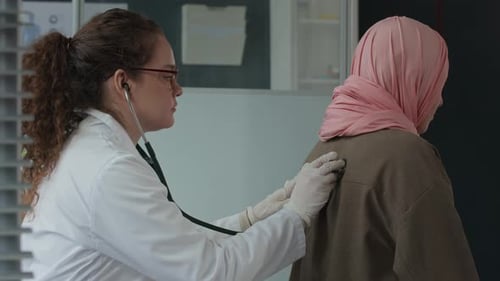 Doctor Listening to Patient Back with Stethoscope
