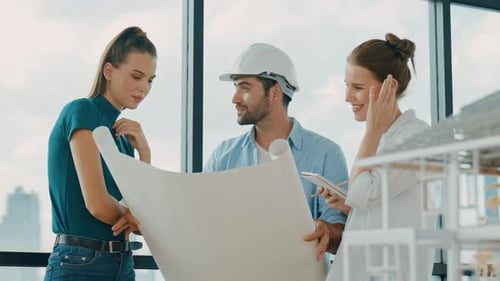 Engineer team talk about design while manager hold at project plan. Tracery