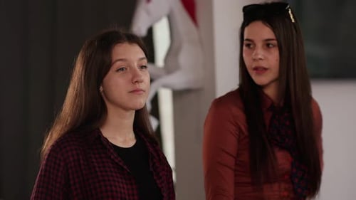 Jeune brune aux cheveux longs discutant avec ses collègues pendant une pause La brune et elle