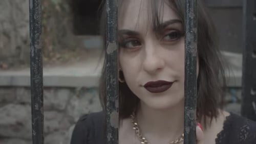 Spooky Female Moving Slowly Inside Old And Rusty Metal Bars While Looking Fearless In The Camera, -