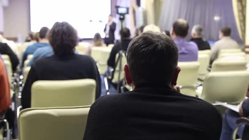 Conference Attendees Listening to Speaker During Corporate Presentation