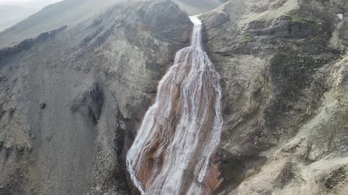 Aerial view of a small waterfall falling from the mountain in Iceland.