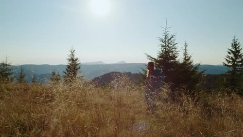 Woman Hiking Mountain Trail Through Field of Tall Grass