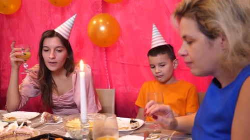Family Celebrates Birthday with Cake and Balloons