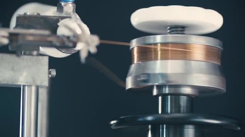 Zeitlupenbetrieb einer sich drehenden mechanischen Spulenwicklung in einem industriellen Arbeitsraum für einen Lautsprecher