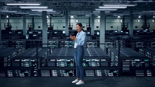 Side View Of Full Body Asian Business Woman Using Mobile Phone In Data Center