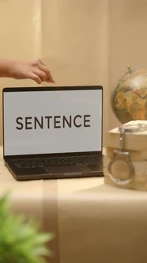 Hand Opens Laptop with 'SENTENCE' on Screen