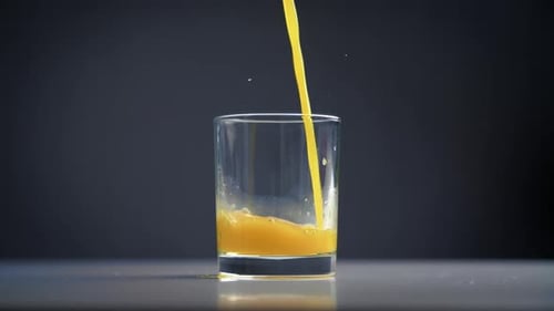 Yellow Liquid Poured into a Glass Cup