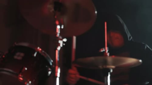 A Drummer Plays Drums In A Dark Hall On A Stage
