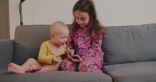 Toddler and Baby Relaxing on a Couch