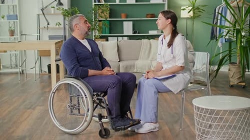 Doctor Consults with Patient in Wheelchair