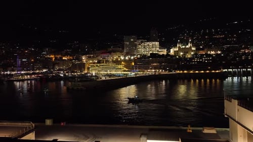 Aerial establiching shot of monte carlo port in the evening with the city lights