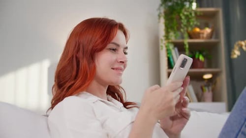 Woman Relaxing on Couch Using Mobile Phone