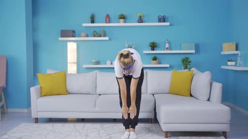 Woman exercising at home stretching her arms. Healthy life fitness.